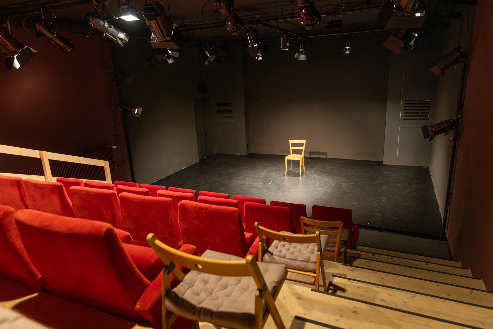 Blick über die roten Sitzreihen auf die Bühne des Theater 111