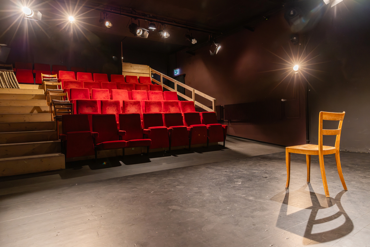 Gelber Stuhl auf der Bühne des Theater 111, dahinter die roten Sitzreihen